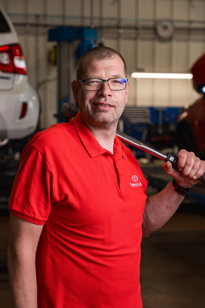 Meccanico sorridente di Trieste Auto con chiave dinamometrica nell'officina Suzuki di Muggia, Trieste
