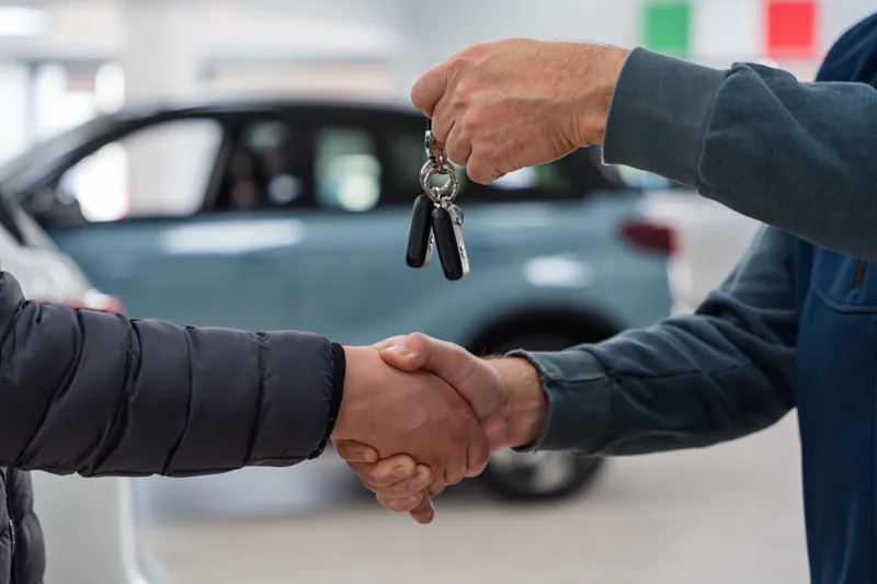 Stretta di mano e consegna delle chiavi di una Suzuki nello showroom di Trieste Auto, concessionaria ufficiale Suzuki a Muggia (Trieste)